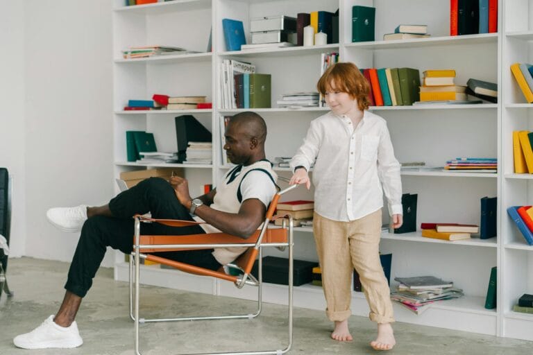 A redheaded child interacting with an adult in a modern office setting.